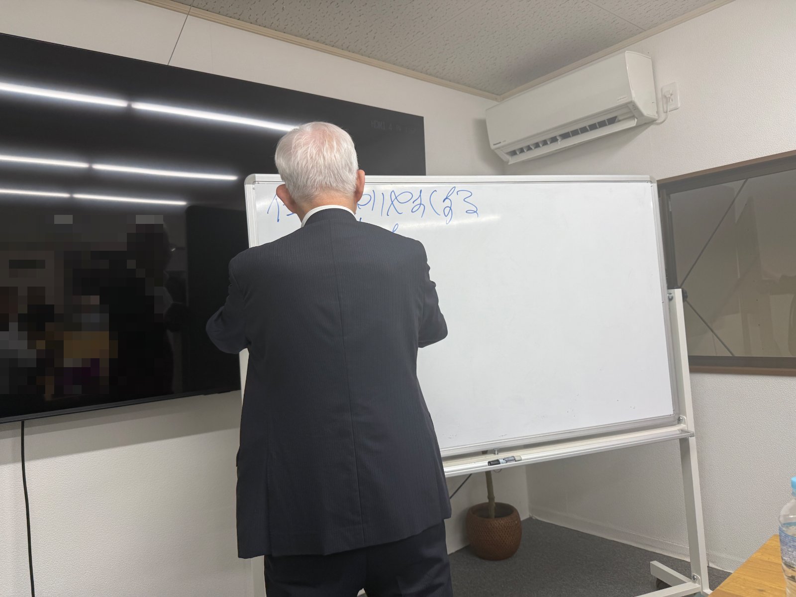株式会社武蔵野・小山昇社長がホワイトボードで語る様子（神戸本社・会議室）